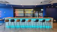 Un bar con una fila de taburetes en una habitación. en Ibis Styles Macaé, en Macaé