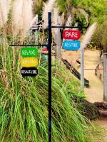 un gruppo di cartelli su un palo in un giardino di Villa da Serra ad Águas da Prata