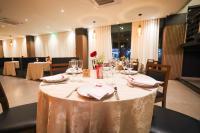 Alta Vista Hotel في Pedro Juan Caballero: غرفة طعام مع طاولة مع الأطباق وكؤوس النبيذ