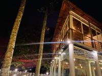 een gebouw met palmbomen er 's nachts voor bij Lavilla Lake Resort And Restaurant in Kollam