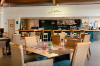 Un restaurante con una mesa y sillas y un bar. en AluaSun Mediterráneo, en S'Algar