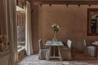 Un comedor con una mesa con un jarrón de flores. en Casa Taberna, en Pedraza-Segovia