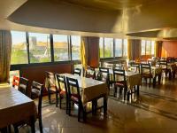 a dining room with tables and chairs and windows at Philae Hotel Aswan in Aswan