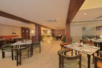 um restaurante com mesas e cadeiras em uma sala em Hotel Grand Continent Premiere, Banjara Hills, Hyderabad em Hyderabad