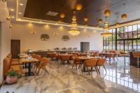 Un comedor con mesas y sillas y ventanas. en Axiom Resorts Luxury Cottages, Arambol, en Arambol