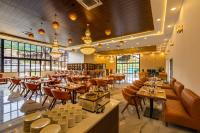 Un restaurante con mesas, sillas y ventanas. en Axiom Resorts Luxury Cottages, Arambol, en Arambol