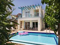 a villa with a swimming pool in front of a house at Villa Lawton - Magnificent sea &amp; mountain views! in Epáno Kefalás