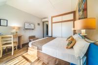 a hotel room with a bed and a desk at Hotel Austral by Exsel in Saint-Denis