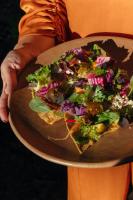 una persona sosteniendo una pizza en un plato en Hotel Casa Cuenca, en Ciudad de México