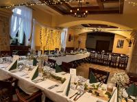 un grupo de mesas en una habitación con mesas blancas en Vadász Panzió és Étterem, en Szombathely