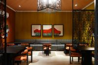um restaurante com mesas e cadeiras e um lustre em The LC Hotel em Lahore