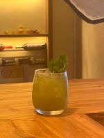 a glass with a green drink on a wooden table at Casa Verde Hostal in Sucre