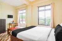 Un dormitorio con una cama grande y dos ventanas. en Collection O Rynjah, en Shillong