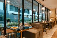 Un restaurante con mesas, sillas y ventanas. en Wekata Luxury, en Kata Beach