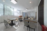 een eetkamer met tafels en stoelen en ramen bij Junxiao Shewen Hotel in Chongyang