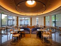 a restaurant with tables and chairs and windows at Ruolinqiao Valley Garden Hotel in Tiantai