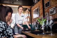 Uma mulher num restaurante a preparar comida. em Scandinavia Zator, an Ascend Collection Resort em Zator