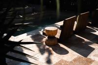 Un banco de tocón de madera junto a una piscina en Hotel Anilevich Mansion, en Beer Sheva