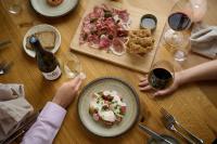 a table with plates of food and a bottle of wine at Seaham Hall and Serenity Spa in Seaham