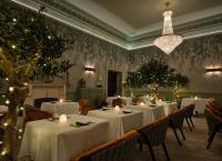 a dining room with tables with candles and christmas lights at Seaham Hall and Serenity Spa in Seaham