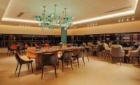 a dining room with tables and chairs and a chandelier at Shanghai Sunshine Hotel - Hongqiao Road Subway Station Branch in Shanghai