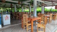 um restaurante com uma mesa e cadeiras de madeira em Hotel Delfín Real em Nuquí