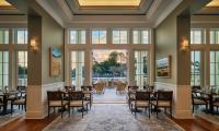 a dining room with tables and chairs and large windows at Montage Palmetto Bluff in Bluffton