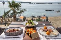 einen Tisch mit zwei Teller Essen und Gläsern Wein in der Unterkunft EdgeWater Beach Hotel in Chania