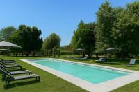 una piscina con tumbonas y sombrillas en un parque en Hotel Capolago, en Varese