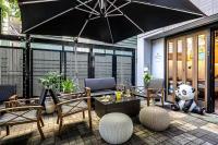 東京にあるKizen Villaのテーブルと椅子と傘のあるパティオ