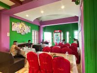 a restaurant with red chairs and a green wall at Hotel Apa Ammaa Lodge, Restaurant, and Spa in Kathmandu