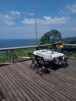 una mesa de comedor en una terraza con vistas al océano en Pousada olhar indigena, en Paraty