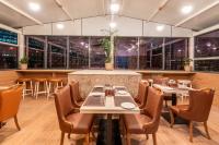 Un restaurante con mesas, sillas y ventanas. en TGI Livancia The Sojourn, en Bangalore