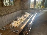 Una mesa larga en una habitación con gafas. en The Kings Arms Inn, en Stockland