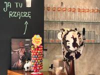 un ristorante con un tavolo con una mucca e un cartello di Szara Willa U Ksawerego a Szklarska Poręba
