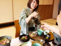 a woman sitting at a table eating food at Kirishima miyama hotel in Kirishima