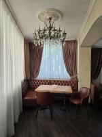 Una habitación con un sofá, una mesa y una lámpara de araña. en Wellotel Chornomorsk, en Chornomorsk