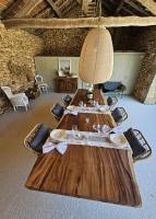 MazeyrollesにあるB&B La Taupinière Rustique table d'hôtes gastronomiqueの部屋にある木製のテーブル、椅子、ランプ