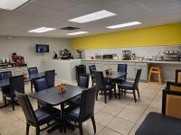 湖城湖城速8酒店的一间带桌椅的餐厅,以及一间厨房内供一人用餐