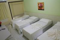 a room with three beds and a mirror at JR Hotel in João Pessoa