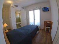 a bedroom with a blue bed and a mirror at Les Palmiers in Fréjus