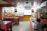 a restaurant with two tables and a counter in a kitchen at JR Hotel in João Pessoa
