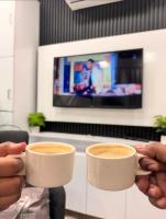 duas pessoas segurando xícaras de café nas mãos em THE ARABiAN VIEW em Pālghar