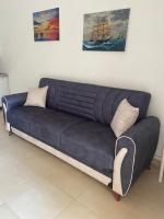 eine blaue Couch im Wohnzimmer in der Unterkunft Montebello Inn apartments in Ulcinj