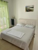 ein Bett mit weißen Laken und Kissen in einem Schlafzimmer in der Unterkunft Montebello Inn apartments in Ulcinj