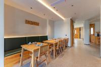 Huangshan Tunxi Shangjiexing Riverview Resort Hotel في Xintan: غرفة طعام مع طاولات خشبية وكبائن خضراء