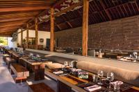 a restaurant with a long row of tables and chairs at Qunci Villas Resort in Senggigi 