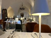 a restaurant with white tables and a clock in a room at Hotel & Spa Wasserschloss Westerburg in Westerburg