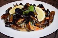 un piatto di cozze e fette di limone su un tavolo di Cosher - Gardenia Palace Apt 7 Free Parking a Pomorie