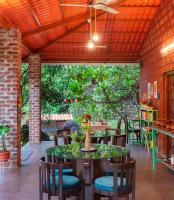 Un patio con mesas y sillas en un restaurante. en Leafyden Forest Cottages, en Talekhār
